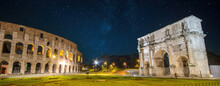 Colosseum (Coliseum) In Rome (Roma), Italy And Arch Of Constantine At Night. Panorama Of Flavian Amphitheatre And Arco De Constantino