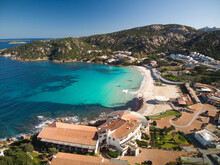 Aerial View Of Beautiful Village, Turquoise Sea And White Beach Of Baja Sardinia Italy