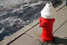 A Traditional Red And White Old Hydrant With Ice And Snow On The Ground