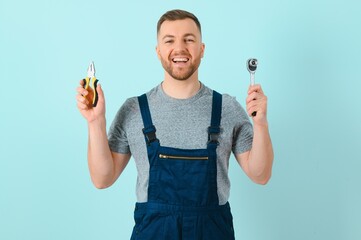 Wall Mural - Portrait of smiling worker in blue uniform isolated on blue background