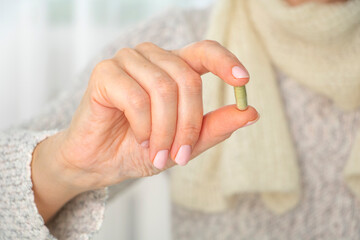 Close up female hand holding capsule of vitamin. Healthy lifestyle concept.