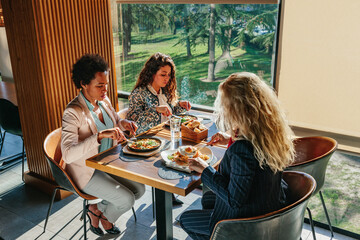 Wall Mural - Female friends having a great time in cafe