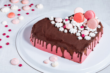 Wall Mural - Pink heart shaped cake with chocolate glaze, meringues and macaroons on top as decoration. Placed on white plate. Valentine's day, mothers day, birthday, celebration concept.