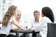 © Qwenergy - Smiling colleagues working together developing business strategy for their next project. Young casually dressed business people having discussion on sunny terrace. Modern job in comfortable conditions