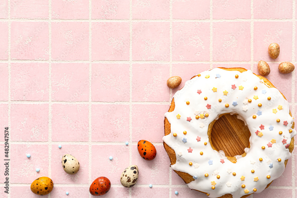 Wooden board with tasty Easter cake and eggs on tile background