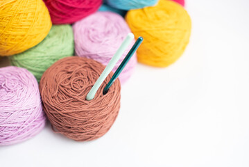 A lot of colorful wool balls of knitted yarn on a white background. The concept of handmade work, needlework and the sale of thread. Balls of alpaca wool, made by hand and colored with plant extract.