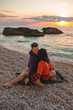 couple lovers at the beach enjoying time together and sunset above the sea