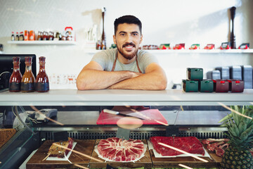 Wall Mural - Portrait of confident young salesman standing in butcher's shop