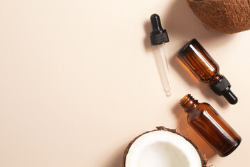 Bottles of coconut oil and fresh coconuts on beige background. Coconut natural cosmetics.