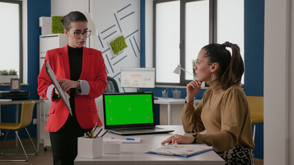 Poster - business women using laptop with green screen and talking about work. colleagues with mockup templat