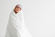 © Prostock-studio - Funny cheerful young caucasian blonde lady in sleep mask wrapped in blanket and enjoy good morning