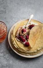 Assiette de crêpes à la crème de marron, yaourt et framboises avec verre de cidre sur une table