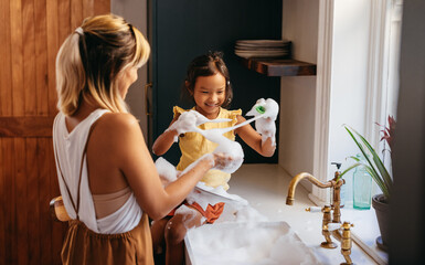 young mother and daughter having fun with soap bubbles