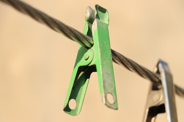 clothespin hanging a metal wire.