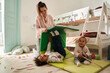 © Yakobchuk Olena - Caucasian mother playing with her cute two son, while little children resting on the floor together