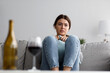 Leinwandbild Motiv Unhappy sorrowful cute young european lady sad from problems with alcohol at home interior