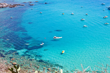 Boats near a rock stone coast. Scenic view of tipycal rocky coastline.