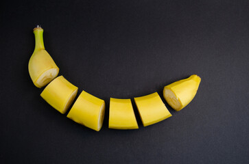 Wall Mural - Banana on a black background. Healthy food. Concept cut yellow banana on a black table.