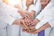 © ASDF - large group of doctors put their hands together.