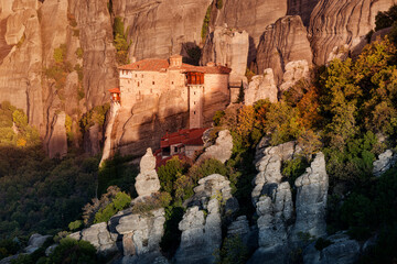 Wall Mural - Atmospheric distant view of the Monastery of Rousanou Agias Barbaras in Meteora. Tourist and pilgrimage inspirations. Natural and religious wonders of Greece.