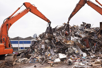 Industrial re-purposing. Cropped shot of two excavators sorting through a pile of scrap metal.