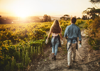 it's been one awesome season. rearview shot of a young man and woman walking though a farm.