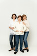 © Vadym - beautiful grandmother smiles being on a white background with her daughters. group of happy women. grandmother hugs her daughter. family day