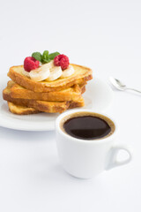 Wall Mural - French toasts with banana, raspberry and coffee cup on the white background. Breakfast. Location vertical.