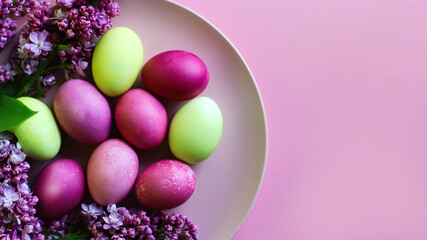  Close-up of beautiful lilac Easter eggs with blooming lilac branches. Easter decor. Selective focus.