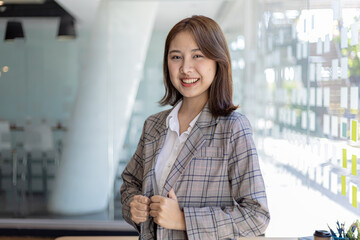 Wall Mural - Portrait of a young beautiful Asian woman in a office room, concept image of Asian business woman, modern female executive, startup business woman, business leader woman.