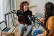 © Vane Nunes - Female host recording radio podcast interview with guest at home office - Focus on latin woman face