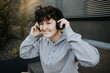 Junger lächelnder Mensch hört Musik mit Kopfhörern 