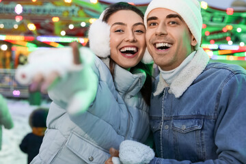 Poster - Loving couple in amusement park at winter night