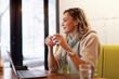 © Teodor Lazarev - Freelance woman having a coffee inside a coffee shop, working on her laptop