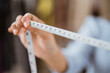 © Odua Images - hand holding tape measure for making a dress