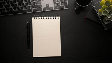 Wall Mural - A mockup of an empty spiral notepad paper on modern black office table.