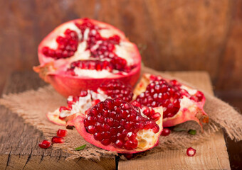 Sticker - Juicy pomegranate and its half Beautiful composition with juicy pomegranates, on old wooden table