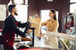 © fotofabrika - Shop assistant handling shopping bag to female customer in grocery store