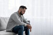 © Prostock-studio - Unhappy young european man sit in living room interior, think about problems