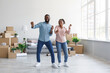 © Prostock-studio - Satisfied young afro american couple dancing in flat with cardboard boxes in home interior, free space