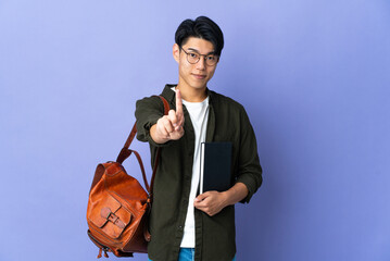 Wall Mural - Young student woman isolated on purple background showing and lifting a finger