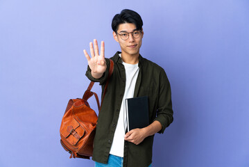 Wall Mural - Young student woman isolated on purple background happy and counting four with fingers