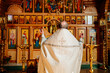 © andrey - view from the back. priest at the iconostasis during the divine service.