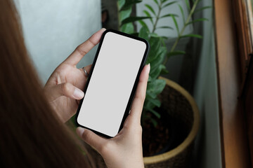 cell phone blank white screen mockup.woman hand holding texting using mobile on desk at office.background empty space for advertise