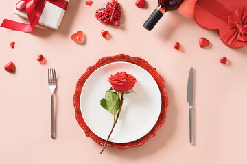 Wall Mural - Valentine's day or birthday table place setting with rose, gift, red wine, hearts on a pink background. View from above. Invitation to festive dinner.