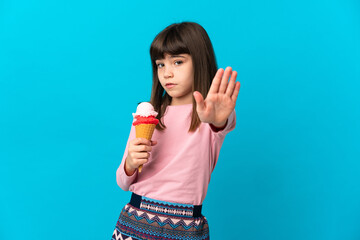 Canvas Print - Little girl with a cornet ice cream isolated on blue background making stop gesture and disappointed