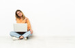 © luismolinero - Young woman with a laptop sitting on the floor suffering from pain in shoulder for having made an effort