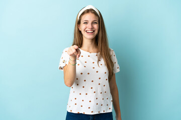 Wall Mural - Young caucasian woman over isolated background surprised and pointing front