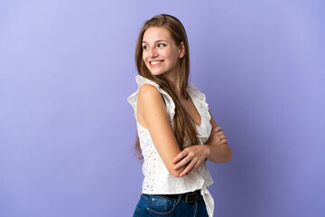 Wall Mural - Young caucasian woman over isolated background looking to the side and smiling