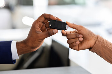 Wall Mural - Closeup Of Car Seller Giving Keys To Black Female Customer In Showroom